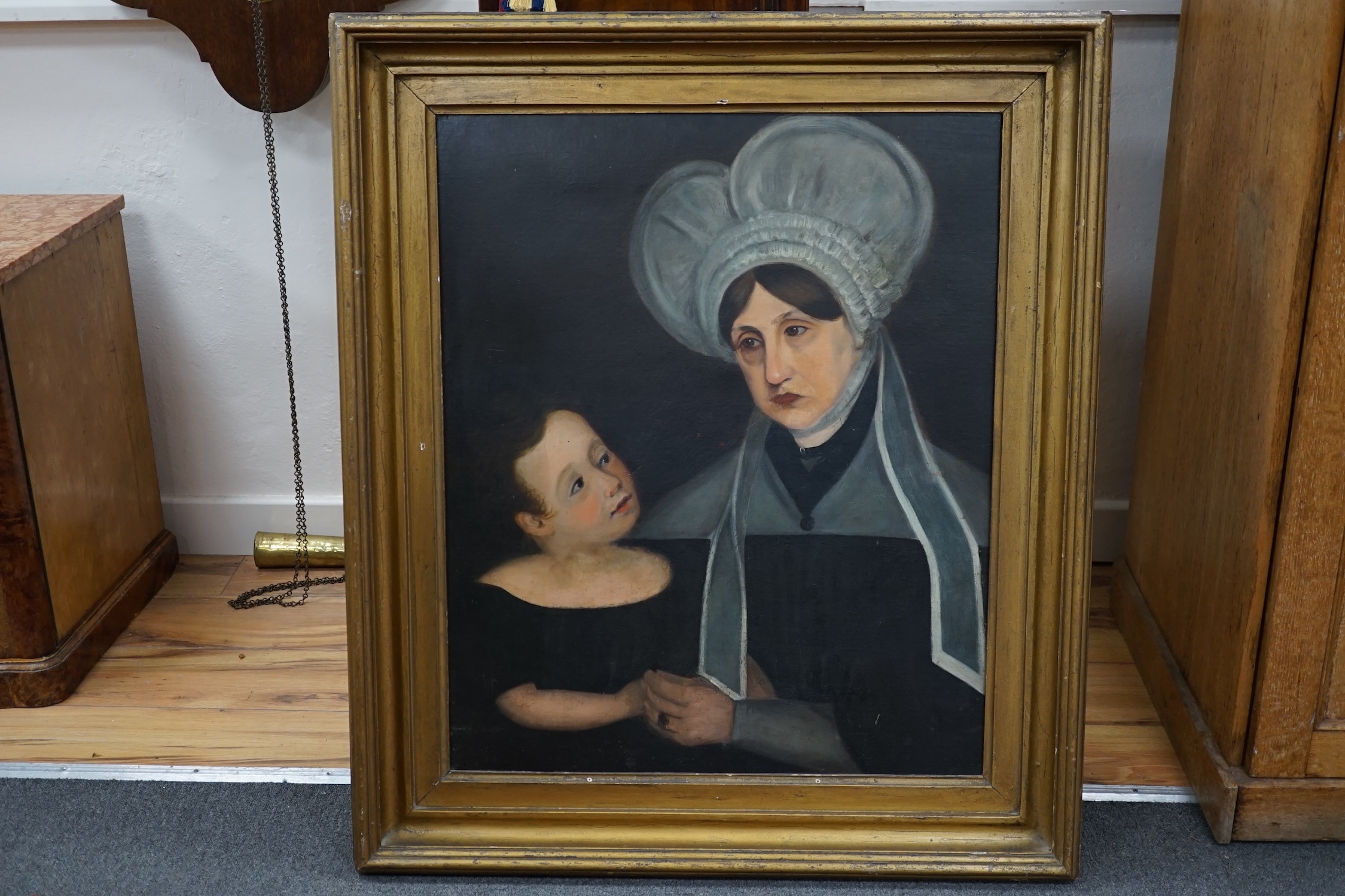 Early to mid 19th century, naive school, oil on canvas, Portrait of a mother and child in mourning, 73 x 60cm, gilt frame. Condition - poor to fair